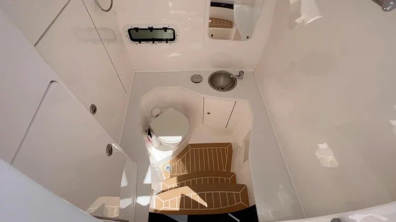 Slide: The Image of 2020 Intrepid 345 Nomad boat bathroom with toilet, sink, and wooden steps. - 9