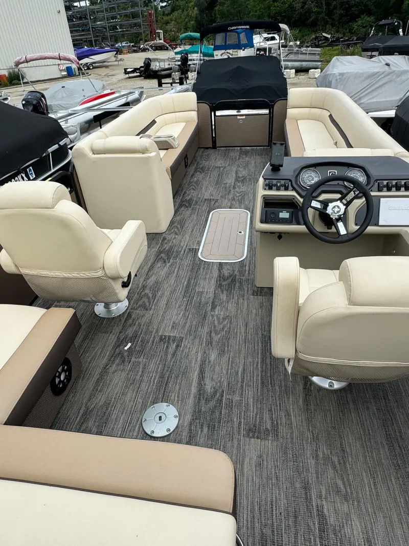 Slide: The Image of 2023 Sweetwater 2486 SFLC pontoon boat interior with beige seating and modern dashboard. - 4