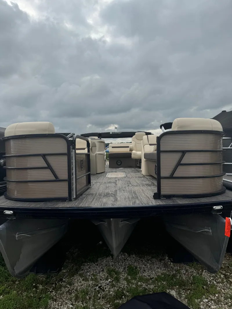 Slide: The Image of 2023 Sweetwater 2486 SFLC pontoon boat with beige seating under cloudy skies. - 8