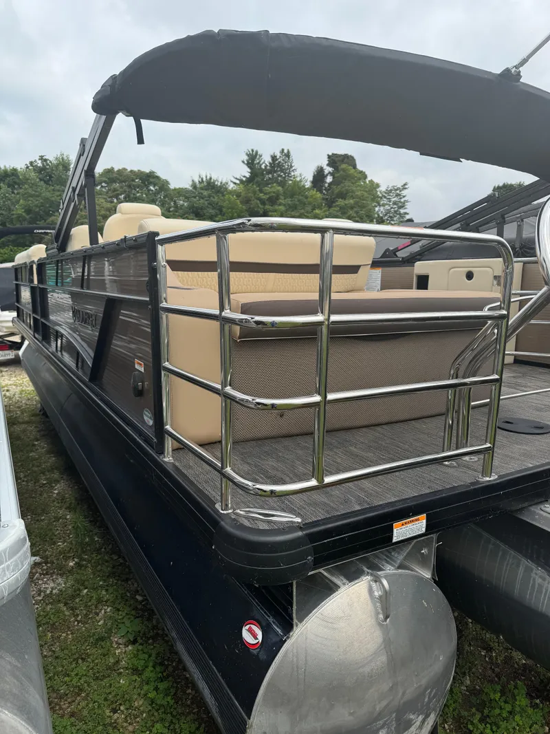 Slide: The Image of 2023 Sweetwater SW246SFL pontoon boat with beige seating and black canopy. - 9