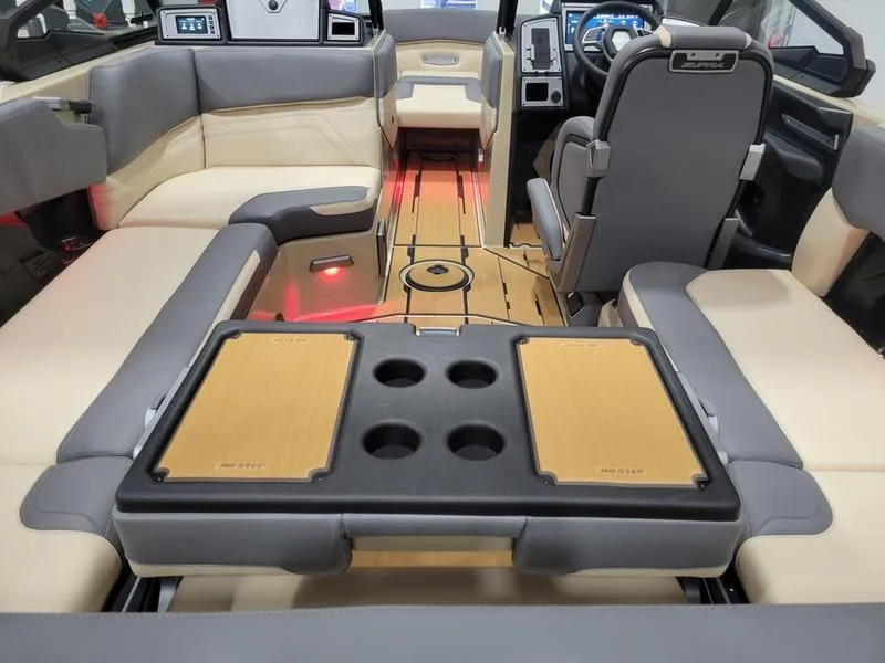 Slide: The Image of 2022 Supra SR400 boat interior with beige and gray seating, wooden flooring, and cup holders. - 40