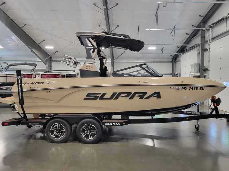 Slide: The Image of 2022 Supra SR400 boat on trailer in indoor showroom. - 6