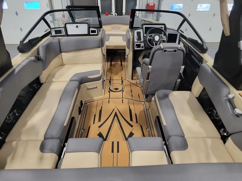 Slide: The Image of 2022 Supra SR400 boat interior with beige and gray seating, modern dashboard, and wooden floor. - 7
