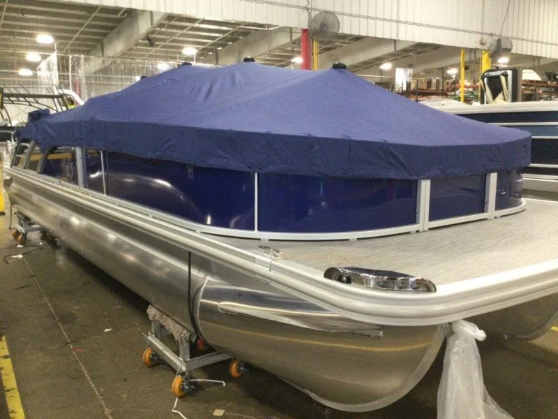 Slide: The Image of 2023 Bennington 25 LTSB pontoon boat with blue cover in a warehouse. - 14