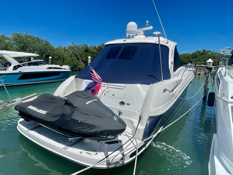Slide: The Image of 2004 Sea Ray 500 Sundancer yacht docked with jet ski, American flag displayed. - 12