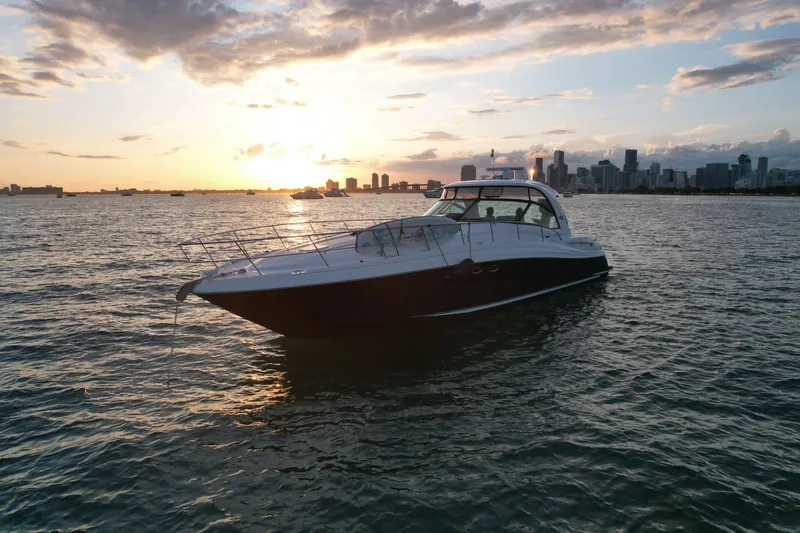 Slide: The Image of 2004 Sea Ray 500 Sundancer yacht at sunset with city skyline in the background. - 20