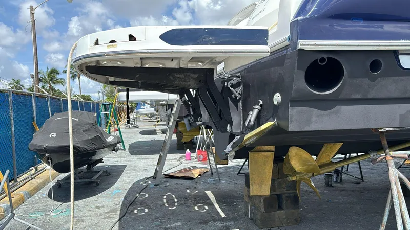 Slide: The Image of 2004 Sea Ray 500 Sundancer yacht under maintenance, showcasing propellers and hull details. - 21