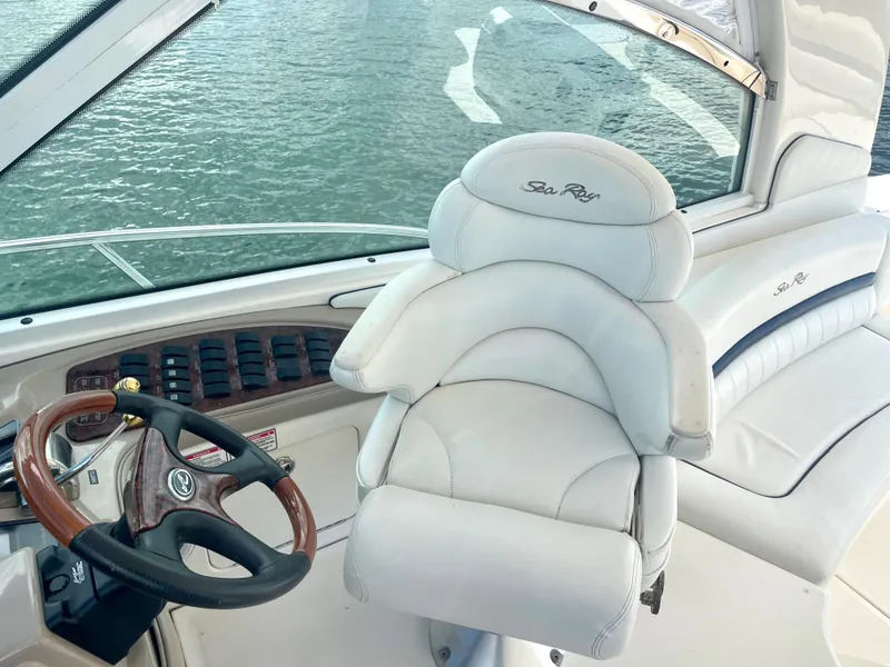 Slide: The Image of 2004 Sea Ray 500 Sundancer helm with white leather captain's chair and wooden steering wheel. - 31