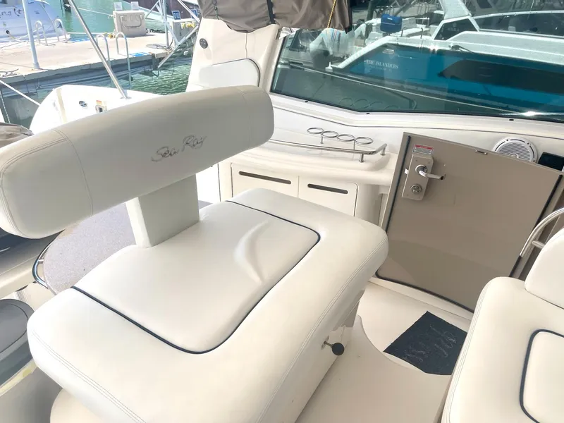 Slide: The Image of 2004 Sea Ray 500 Sundancer cockpit with white seating and helm controls. - 33