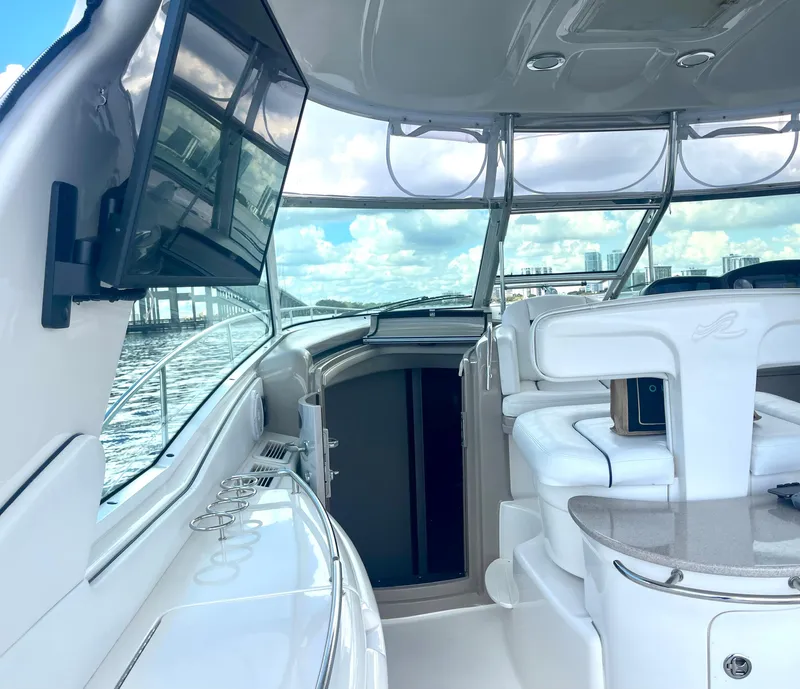 Slide: The Image of Interior of 2004 Sea Ray 500 Sundancer yacht with white seating and mounted TV. - 34