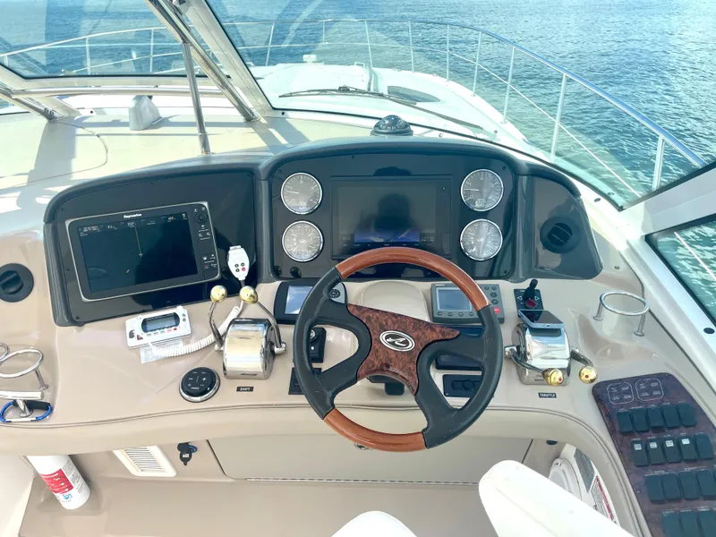 Slide: The Image of Helm of 2004 Sea Ray 500 Sundancer with navigation equipment and wooden steering wheel. - 35