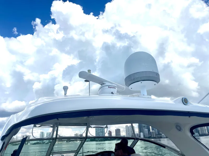 Slide: The Image of 2004 Sea Ray 500 Sundancer yacht with city skyline and cloudy sky. - 49