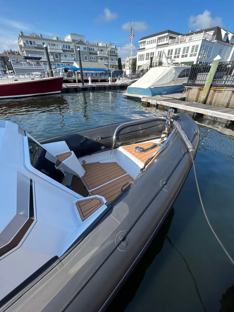 Slide: The Image of 2020 Protector 330 Targa boat docked in a marina with waterfront buildings. - 11