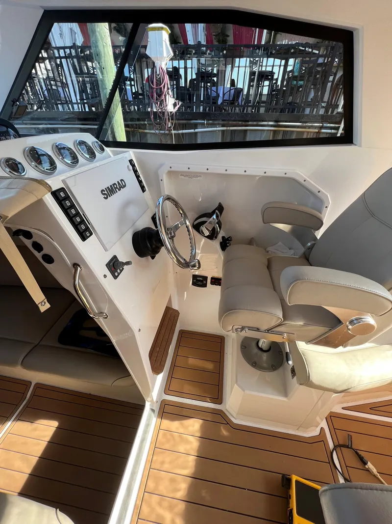 Slide: The Image of 2020 Protector 330 Targa boat interior with steering wheel and control panel. - 16
