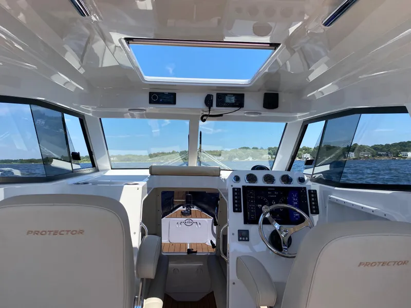 Slide: The Image of Interior view of 2020 Protector 330 Targa boat cockpit with modern controls and panoramic windows. - 22