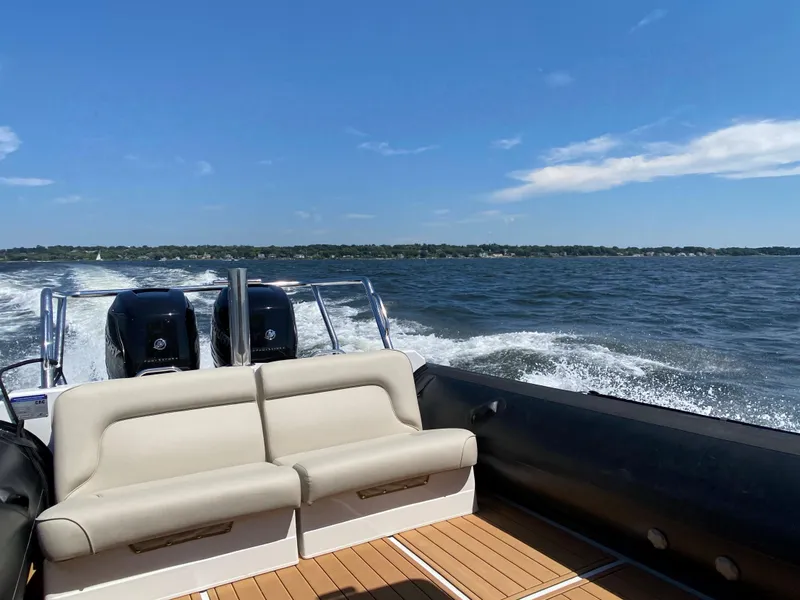 Slide: The Image of 2020 Protector 330 Targa boat cruising on open water under clear blue skies. - 23