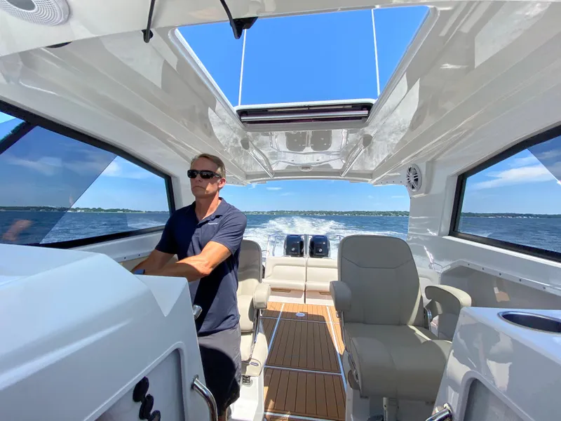 Slide: The Image of Man piloting 2020 Protector 330 Targa boat on open water. - 24