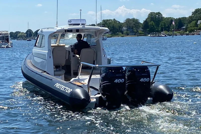 Slide: The Image of 2020 Protector 330 Targa boat cruising on a sunny day with twin 400 engines. - 25