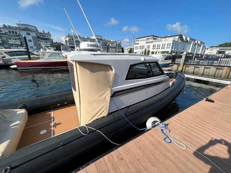 Slide: The Image of 2020 Protector 330 Targa boat docked at marina under clear blue sky. - 4