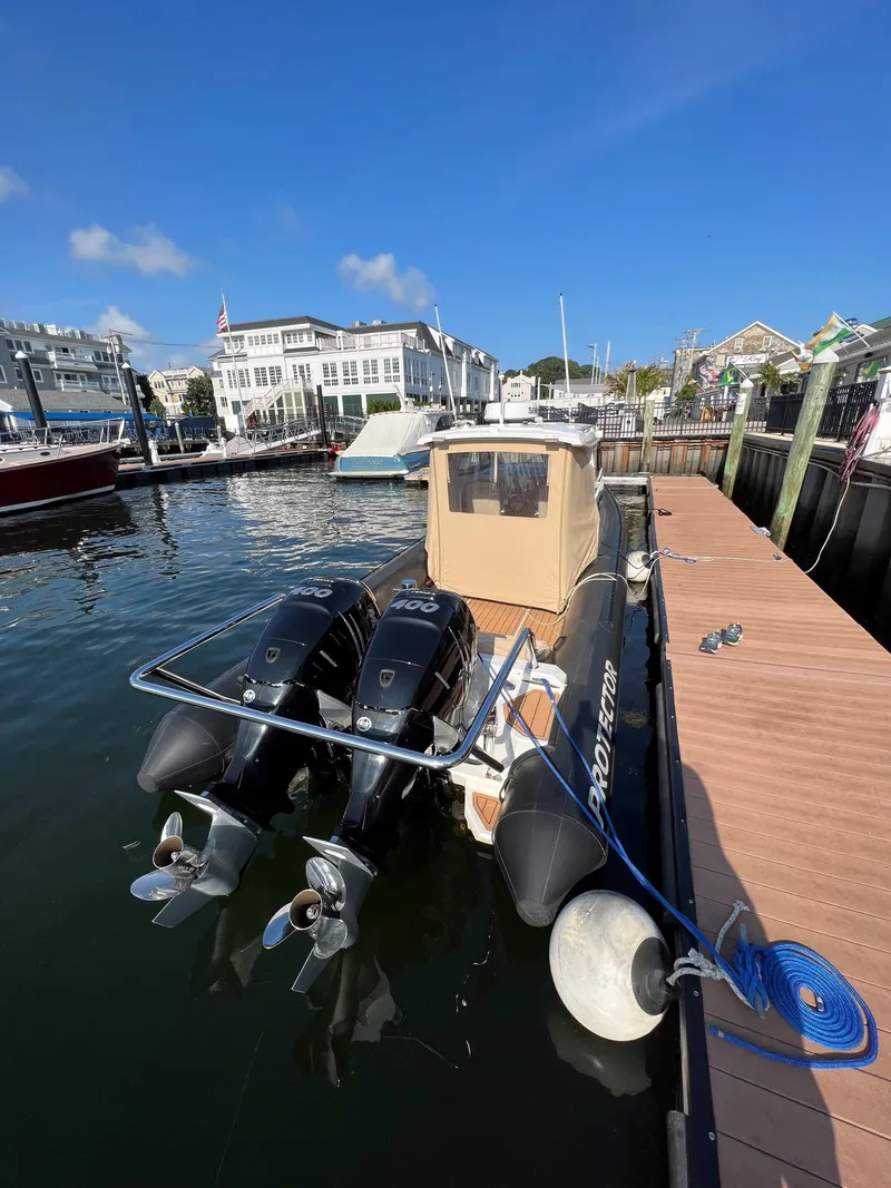 Slide: The Image of 2020 Protector 330 Targa boat docked at marina with twin engines. - 5