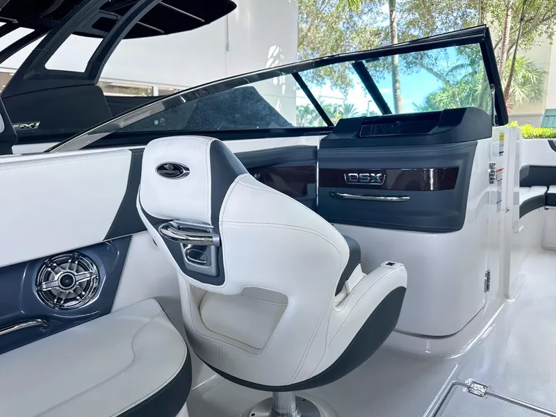 Slide: The Image of Interior of 2025 Chaparral 270 OSX OB boat with sleek white seating and modern dashboard. - 16