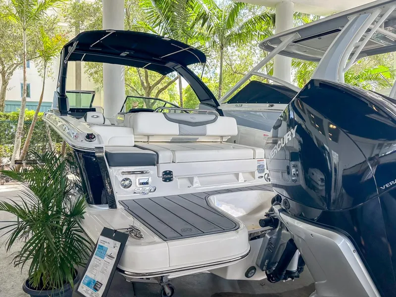 Slide: The Image of 2025 Chaparral 270 OSX OB boat displayed outdoors with lush greenery. - 2