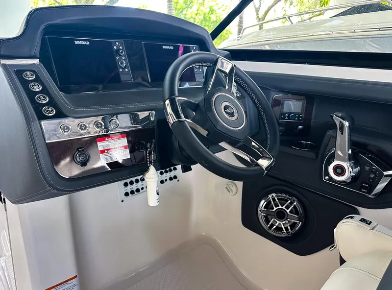Slide: The Image of 2025 Chaparral 270 OSX OB boat dashboard with steering wheel and control panel. - 23