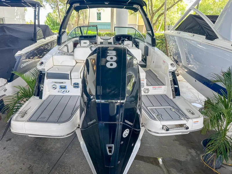 Slide: The Image of 2025 Chaparral 270 OSX OB boat with powerful outboard engine, docked in a marina. - 3