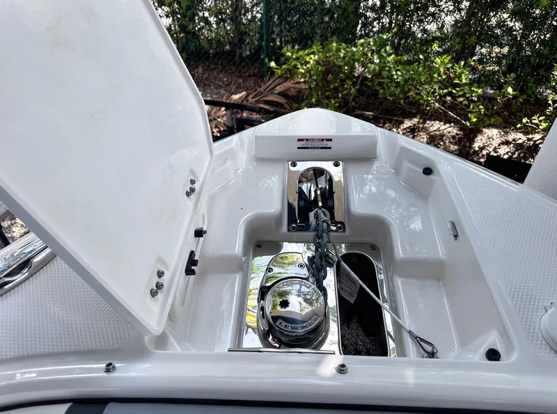 Slide: The Image of Anchor compartment of 2025 Chaparral 270 OSX OB boat, open lid, shiny metal details. - 30