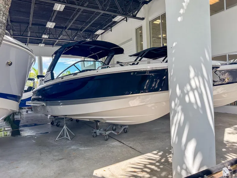 Slide: The Image of 2025 Chaparral 270 OSX OB boat displayed indoors, featuring sleek design and modern aesthetics. - 6