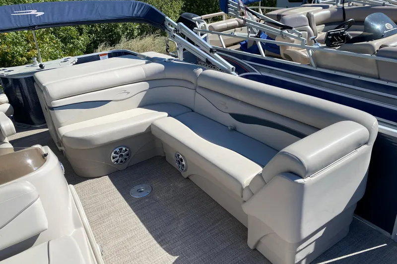 Slide: The Image of 2018 Bennington 22 SFX pontoon boat with beige seating and carpeted deck. - 11