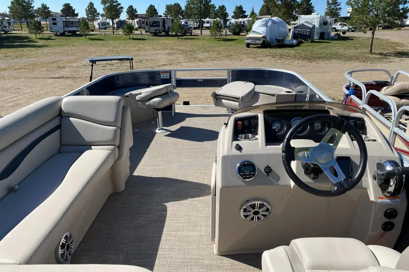 Slide: The Image of 2018 Bennington 22 SFX pontoon boat interior with beige seating and steering console. - 8