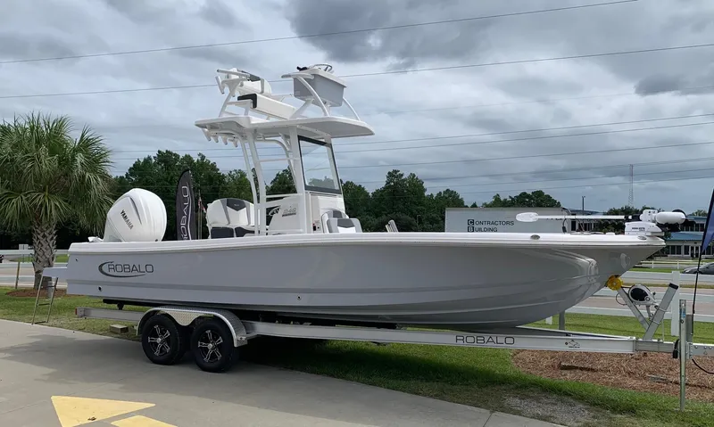 The Image of 2024 Robalo 246 Cayman Sky Deck boat on a trailer, side view. - 0