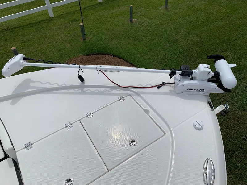 Slide: The Image of Robalo 246 Cayman Sky Deck 2026 with trolling motor on deck, grassy background. - 15