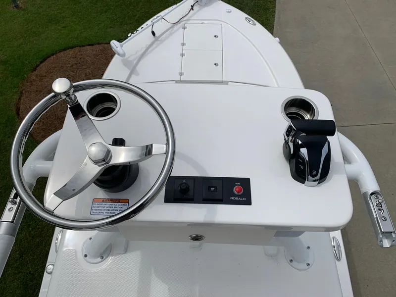 Slide: The Image of 2026 Robalo 246 Cayman Sky Deck boat helm with steering wheel and controls. - 4