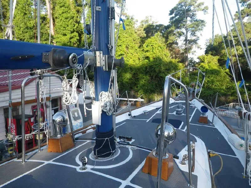 Slide: The Image of 1981 Southern Cross 39' sailboat deck with mast and rigging, surrounded by lush greenery. - 10