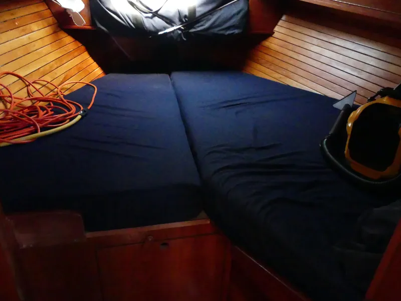 Slide: The Image of Cozy cabin interior of 1981 Southern Cross 39' sailboat with blue bedding and wooden paneling. - 28