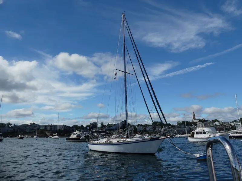 Slide: The Image of 1981 Southern Cross 39' sailboat anchored in a scenic harbor under a clear blue sky. - 3