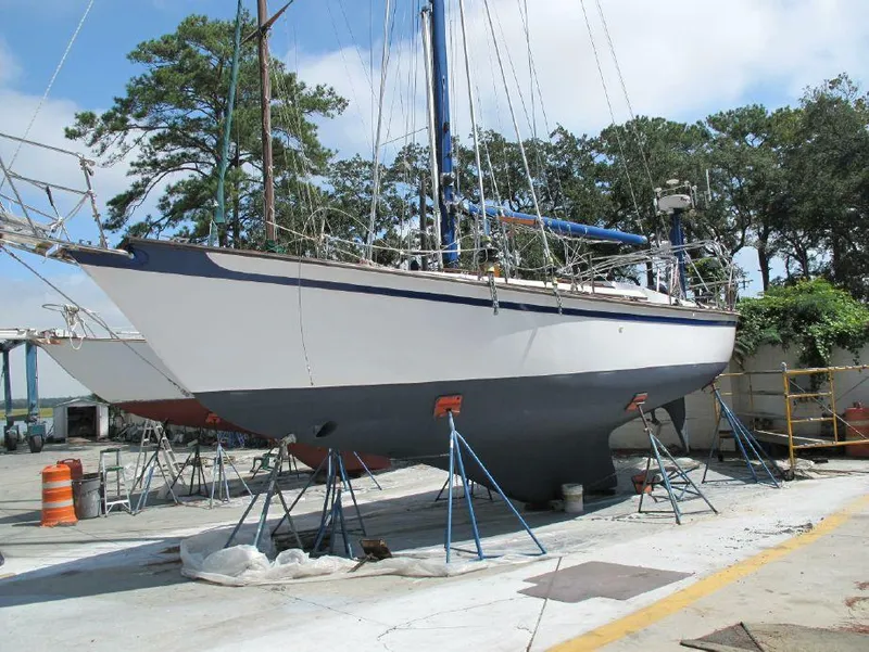 Slide: The Image of 1981 Southern Cross 39' sailboat on stands in a boatyard, surrounded by trees. - 33