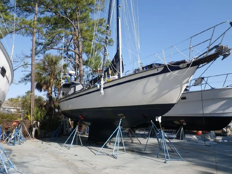 Slide: The Image of 1981 Southern Cross 39' sailboat on stands, surrounded by trees and other boats. - 35