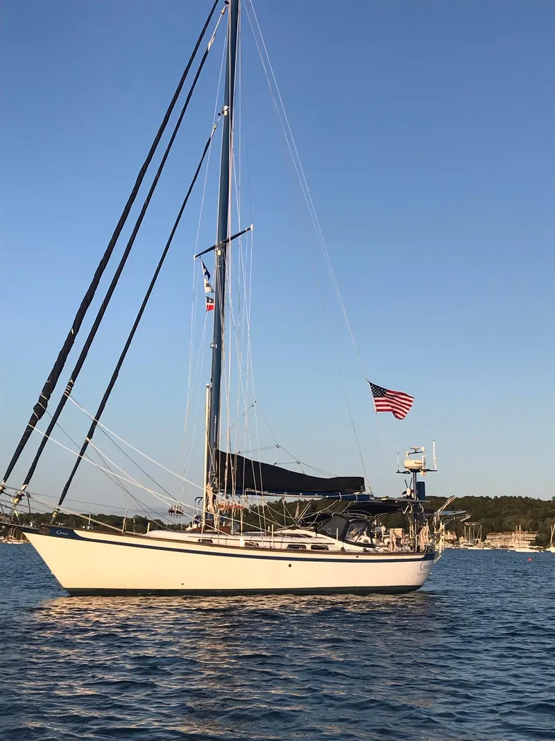 Slide: The Image of 1981 Southern Cross 39' sailboat on calm water with American flag. - 4