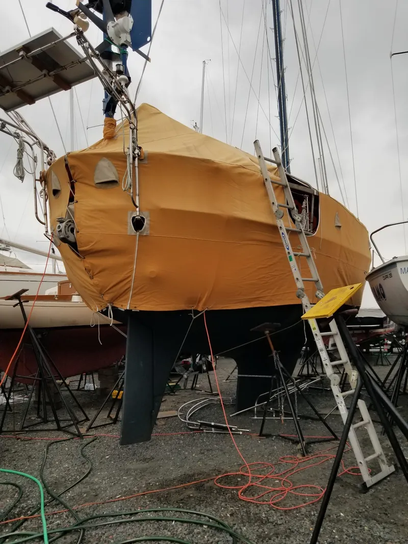 Slide: The Image of 1981 Southern Cross 39' sailboat under maintenance, covered in a yellow tarp, with ladders and equipment. - 40