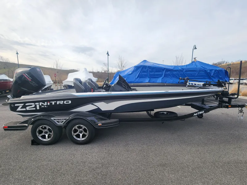 Slide: The Image of 2023 Nitro Z21 XL boat on trailer, parked outdoors. - 2