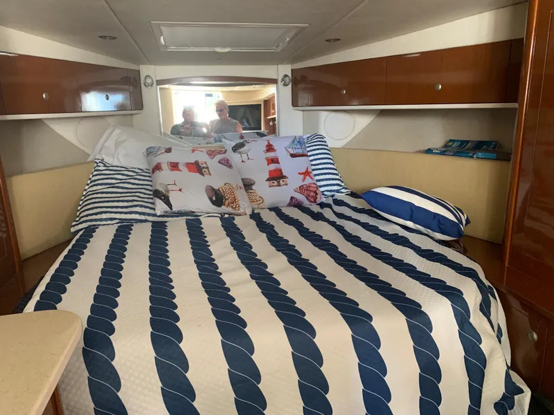 Slide: The Image of Cozy cabin interior of 2008 Sea Ray 330 Sundancer with nautical-themed bedding. - 17