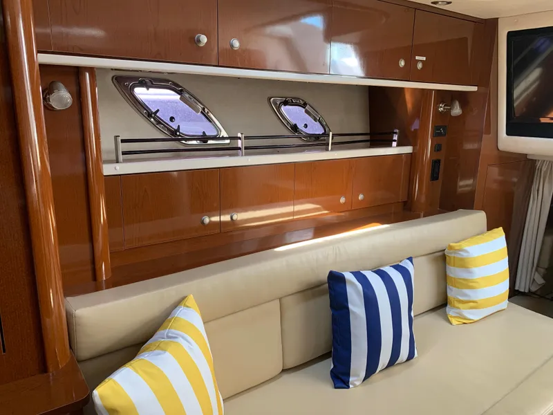 Slide: The Image of Interior of 2008 Sea Ray 330 Sundancer with striped cushions and wooden cabinetry. - 23