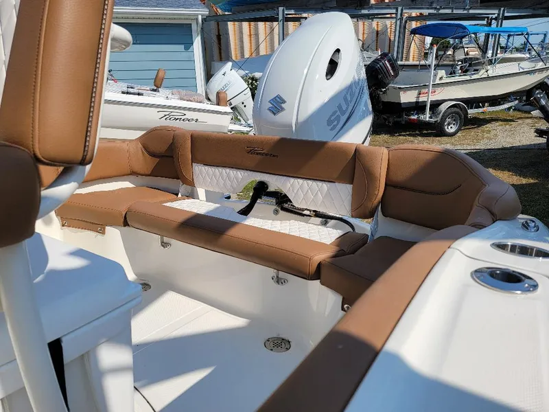 Slide: The Image of 2023 Pioneer 202 Islander boat interior with tan seating and Suzuki outboard motor. - 3