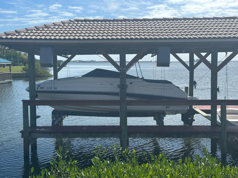 Slide: The Image of 2003 Chaparral 215 SS Cuddy boat docked in a covered boat lift on a sunny day. - 3