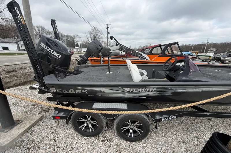 Slide: The Image of 2022 SeaArk Stealth 210 boat with Suzuki engine on trailer, parked outdoors. - 13