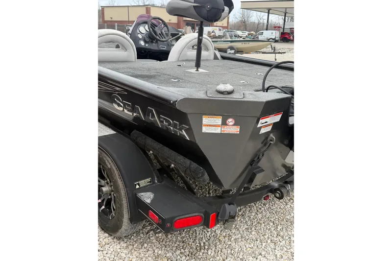 Slide: The Image of 2022 SeaArk Stealth 210 boat, rear view, on a trailer in a gravel lot. - 4