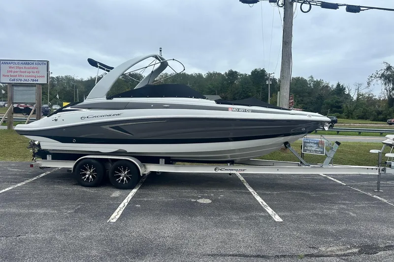 The Image of 2023 Crownline 270 SS boat on trailer in parking lot, overcast sky. - 0